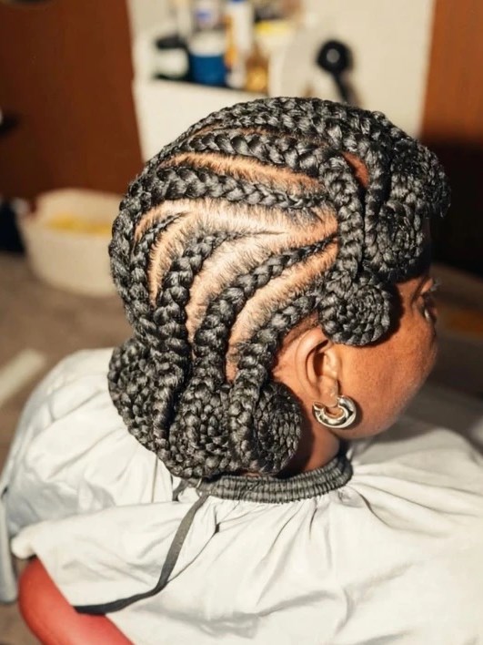 Feed-in cornrows braided in a curved pattern with coiled ends