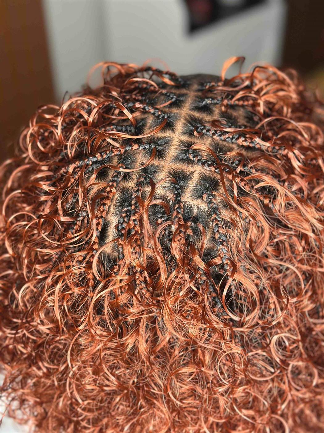 Close-up of copper Italian braids: small braids and square parts under loose curls